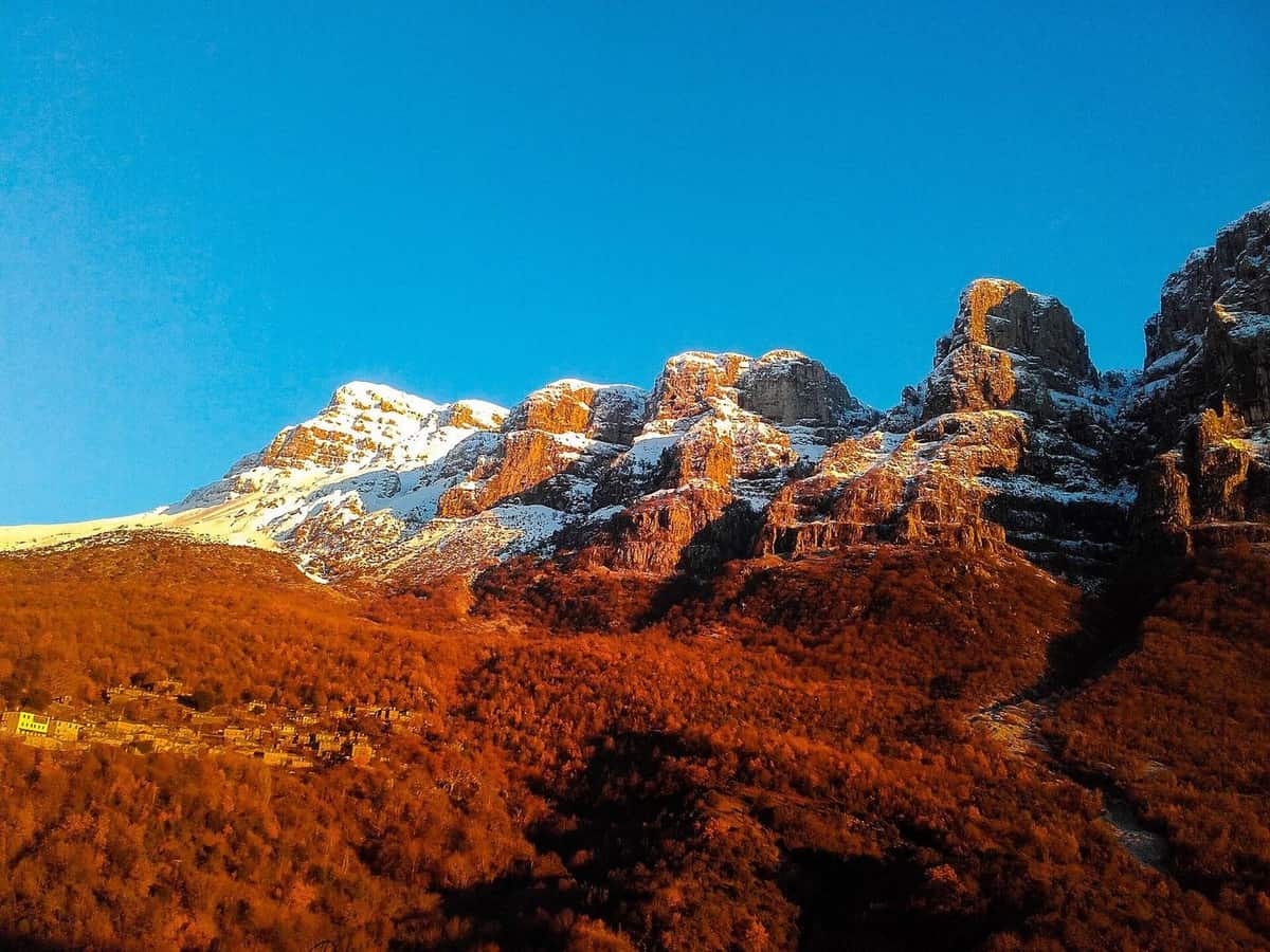 Οι κορυφές της Αστράκας με χιόνι πάνω από φθινοπωρινή πλαγιά