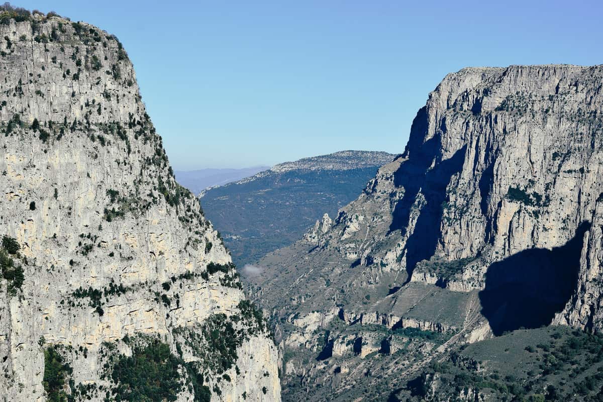 Τα κάθετα ασβεστολιθικά τοιχώματα του φαραγγιού του Βίκου κάτω από καθαρό γαλάζιο ουρανό