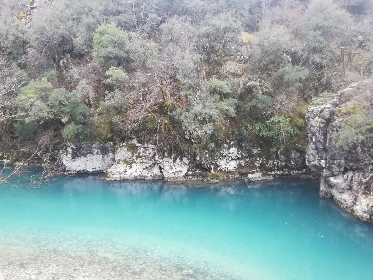 Τιρκουάζ νερά ποταμού ανάμεσα σε βράχια και πράσινο